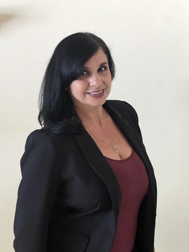 Vivian Alonso, Solution Consultant, standing in front of a white office wall.